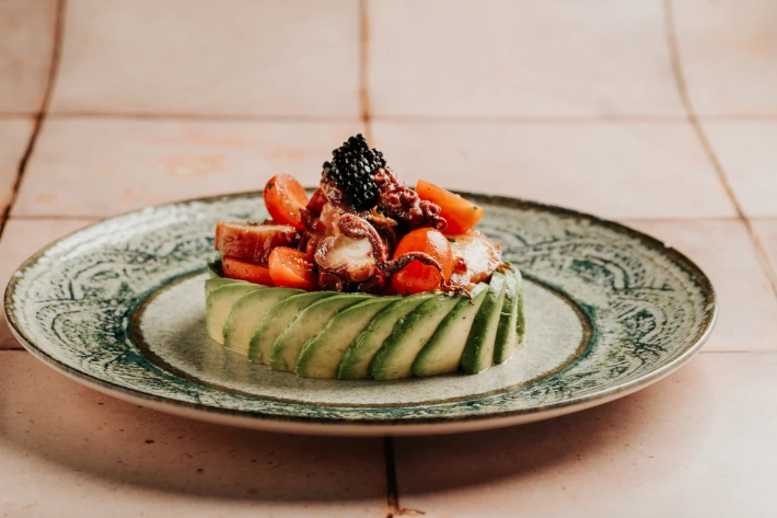 Ensalada de pulpo, aguacate, tomates cherry y cilantro